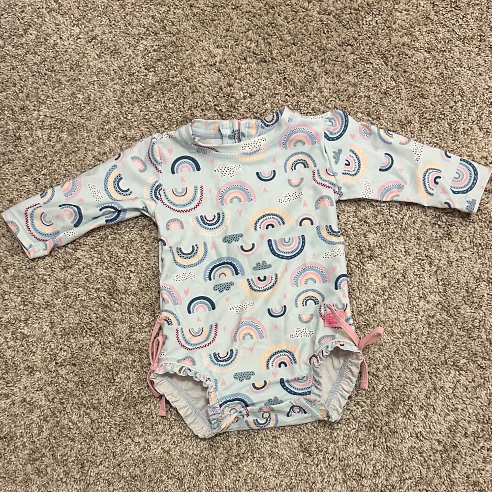Ruffle Butts long sleeve one piece rash guard in “chase the rainbow”, 3-6mo